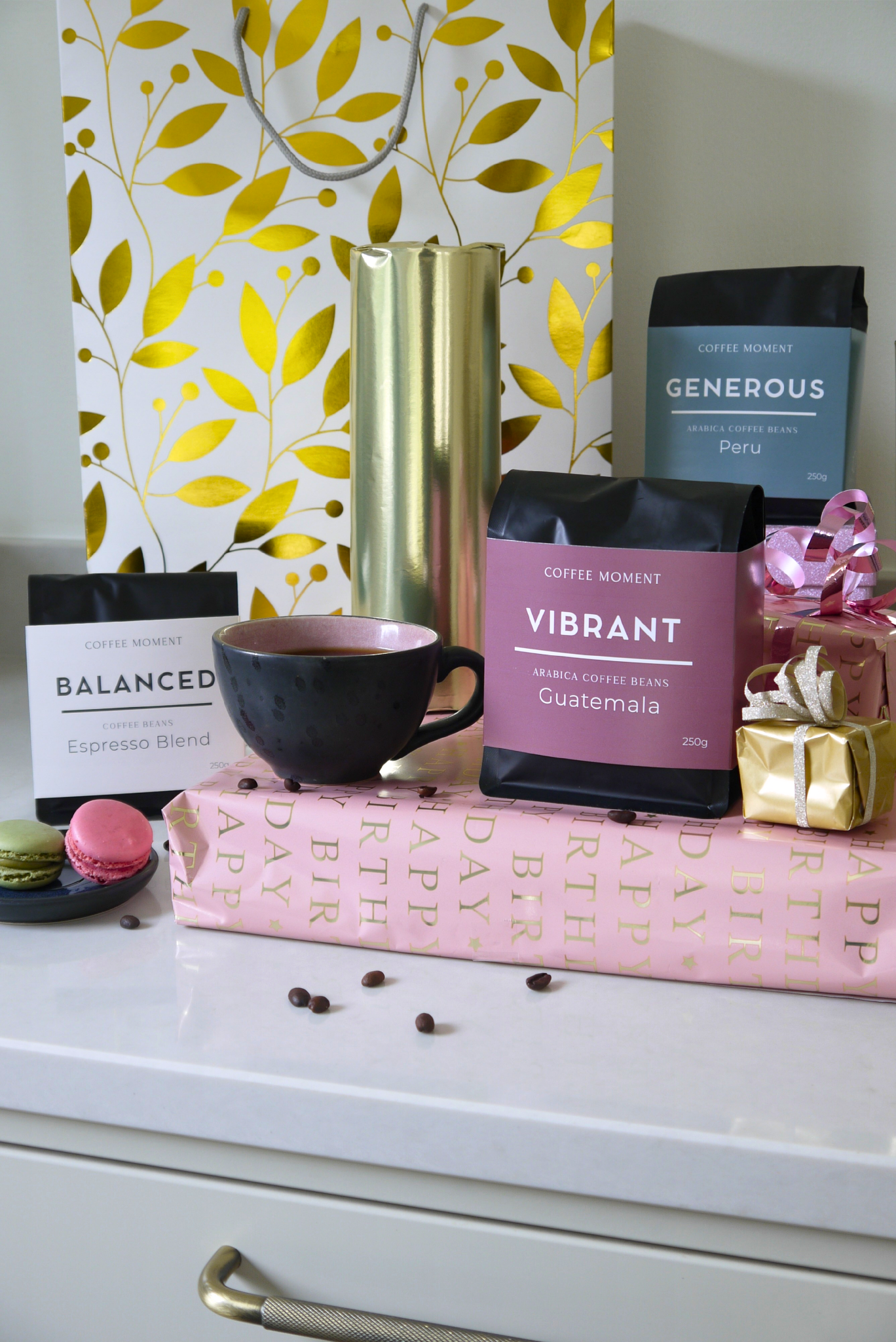 Coffee-themed decor with coffee bags labled 'Balanced', 'Vibrant' and 'Generous', a cup, and decorative items on a surface.