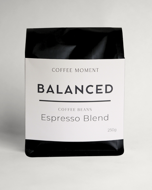 Coffee beans package labeled 'Balanced Espresso Blend' from 'Coffee Moment' on a light gray background
