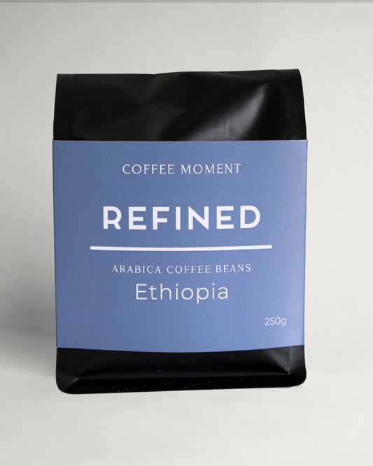 Coffee beans package labeled 'Refined Ethiopia' by 'Coffee Moment' on a gray background